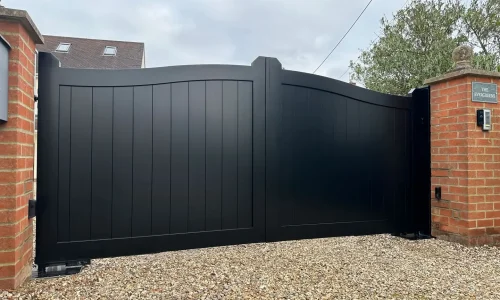 A black aluminium gates with a gently curved top, adding sophistication and security to the property entrance. Gates Wellington provides durable aluminium gates. A black aluminium gates with a gently curved top, adding sophistication and security to the property entrance. Gates Wellington provides durable aluminium gates.